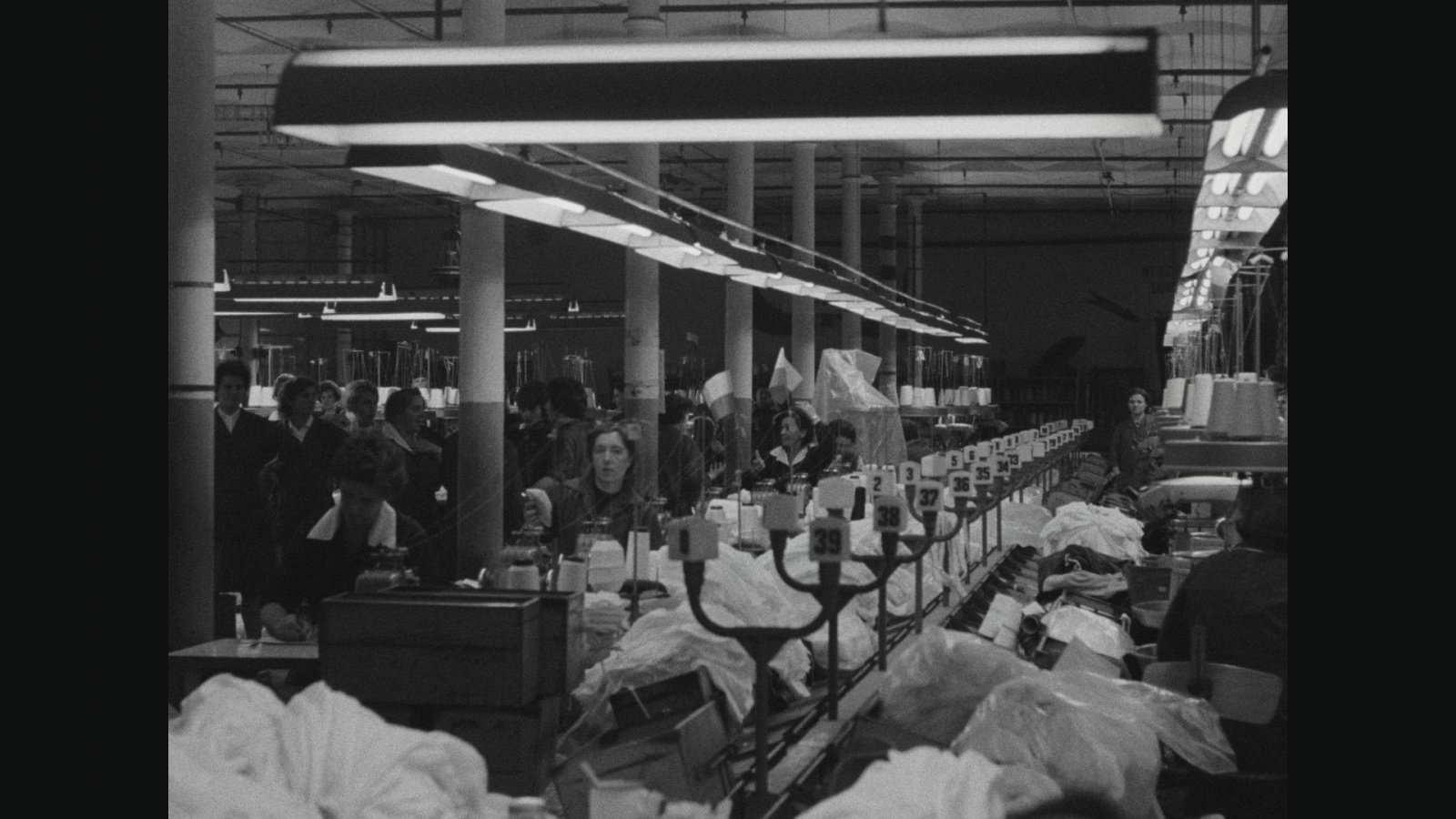 rus: стара фотографія швейної фабрики, справа машини, зліва купа жінок