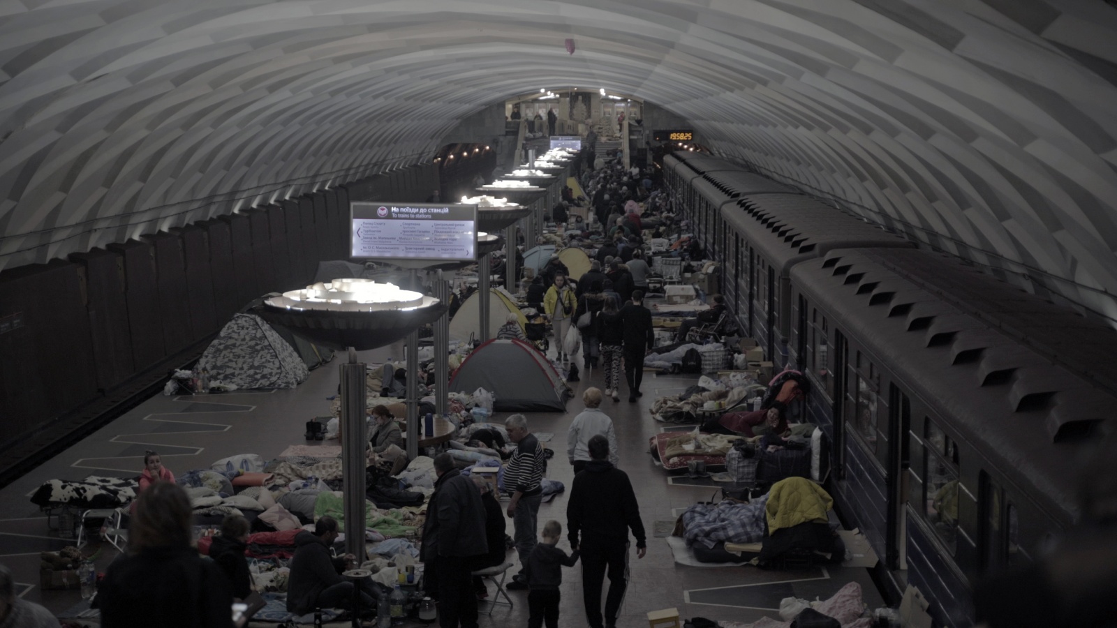 rus: Люди ховаються на станції метро, яка слугує укриттям.