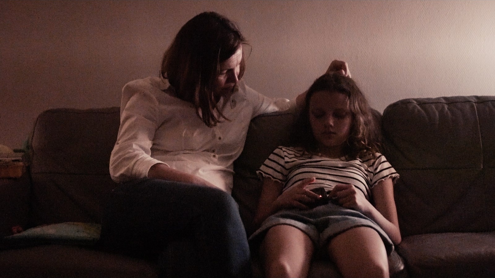 rus: Мати й донька сидять на дивані.