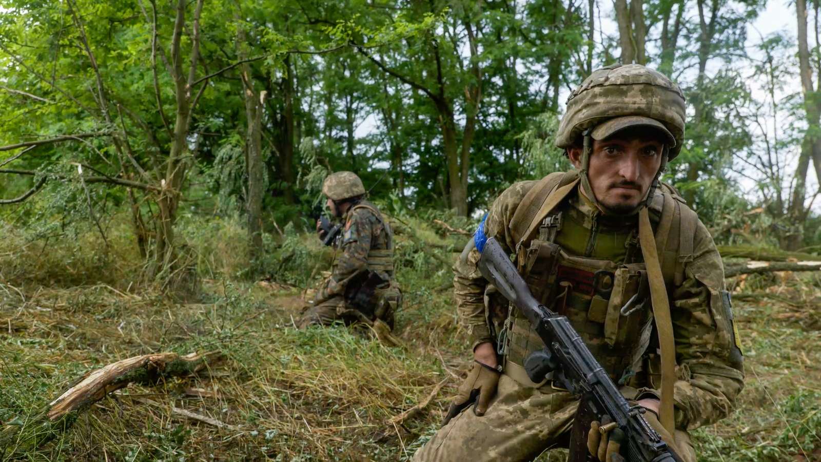 eng: A soldier with a machine gun looks at the camera.