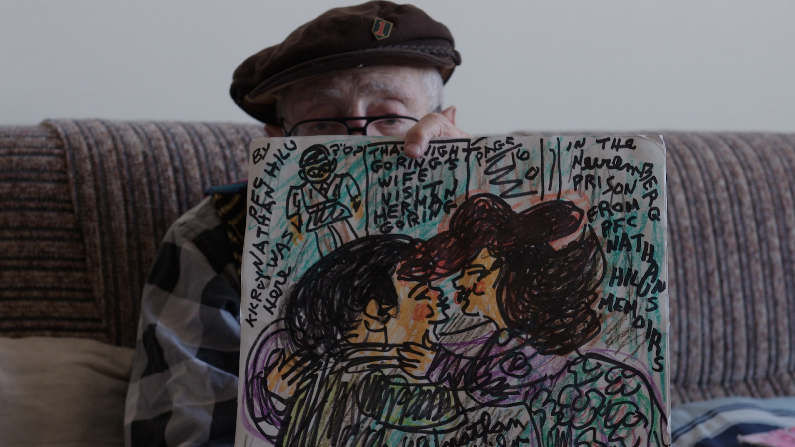 rus: Літній чоловік тримає малюнок пари, яка цілується.