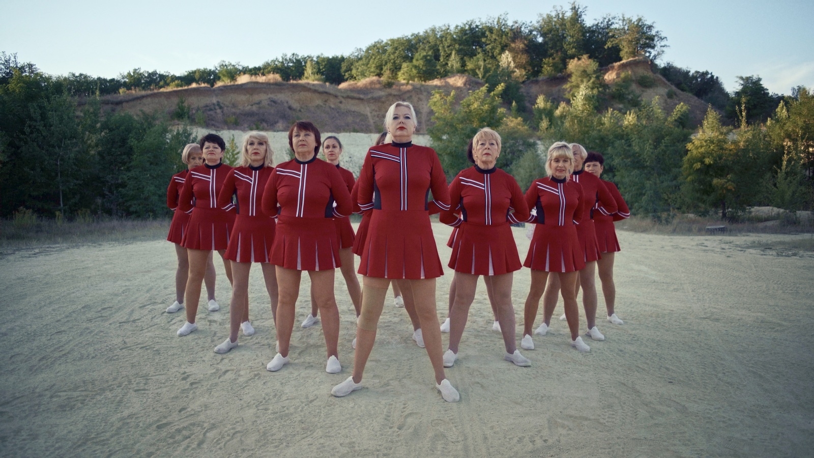 eng: A cheerleading squad of senior women in red suits.