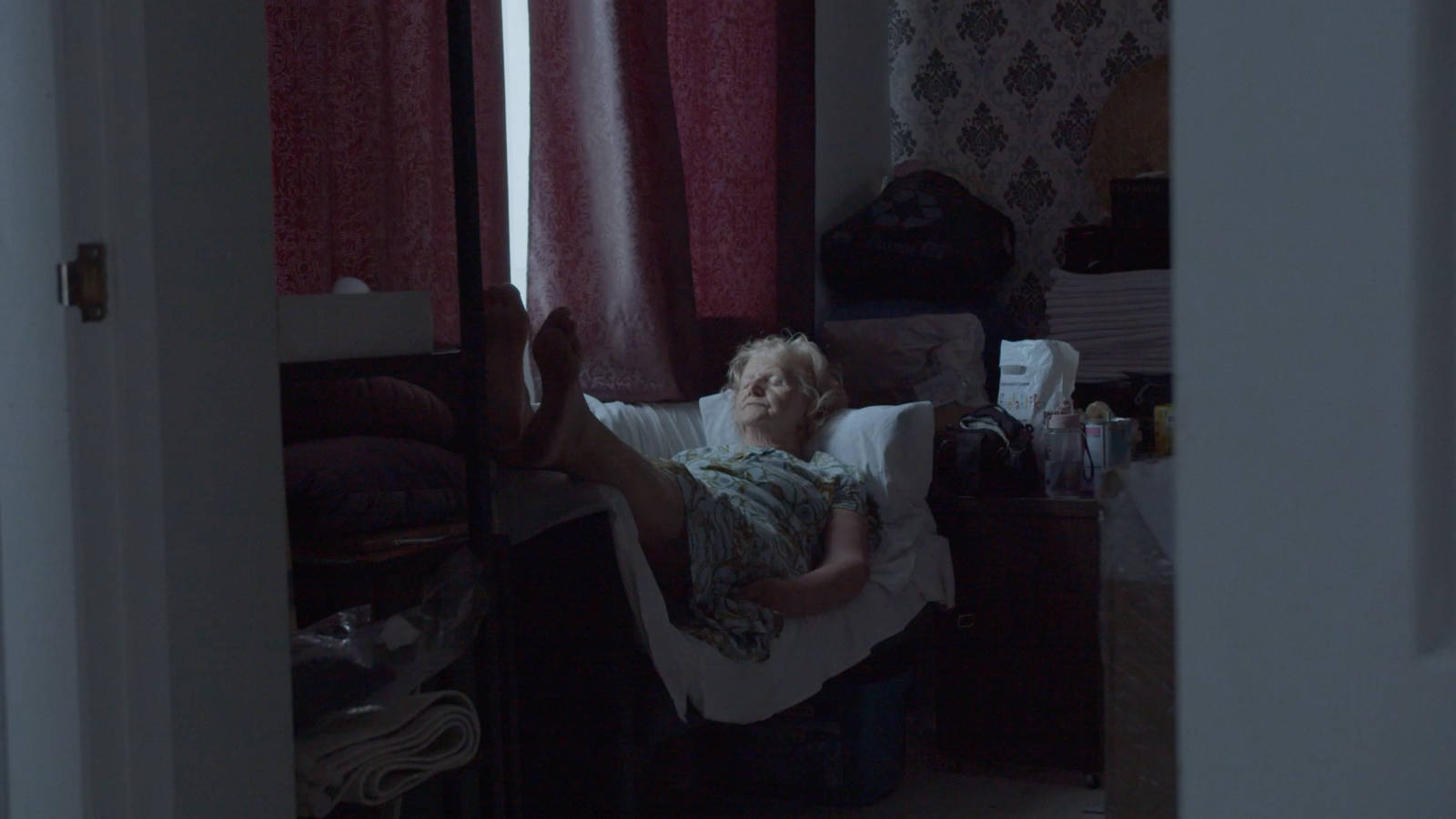 rus: Старенька жінка лежить на ліжку.