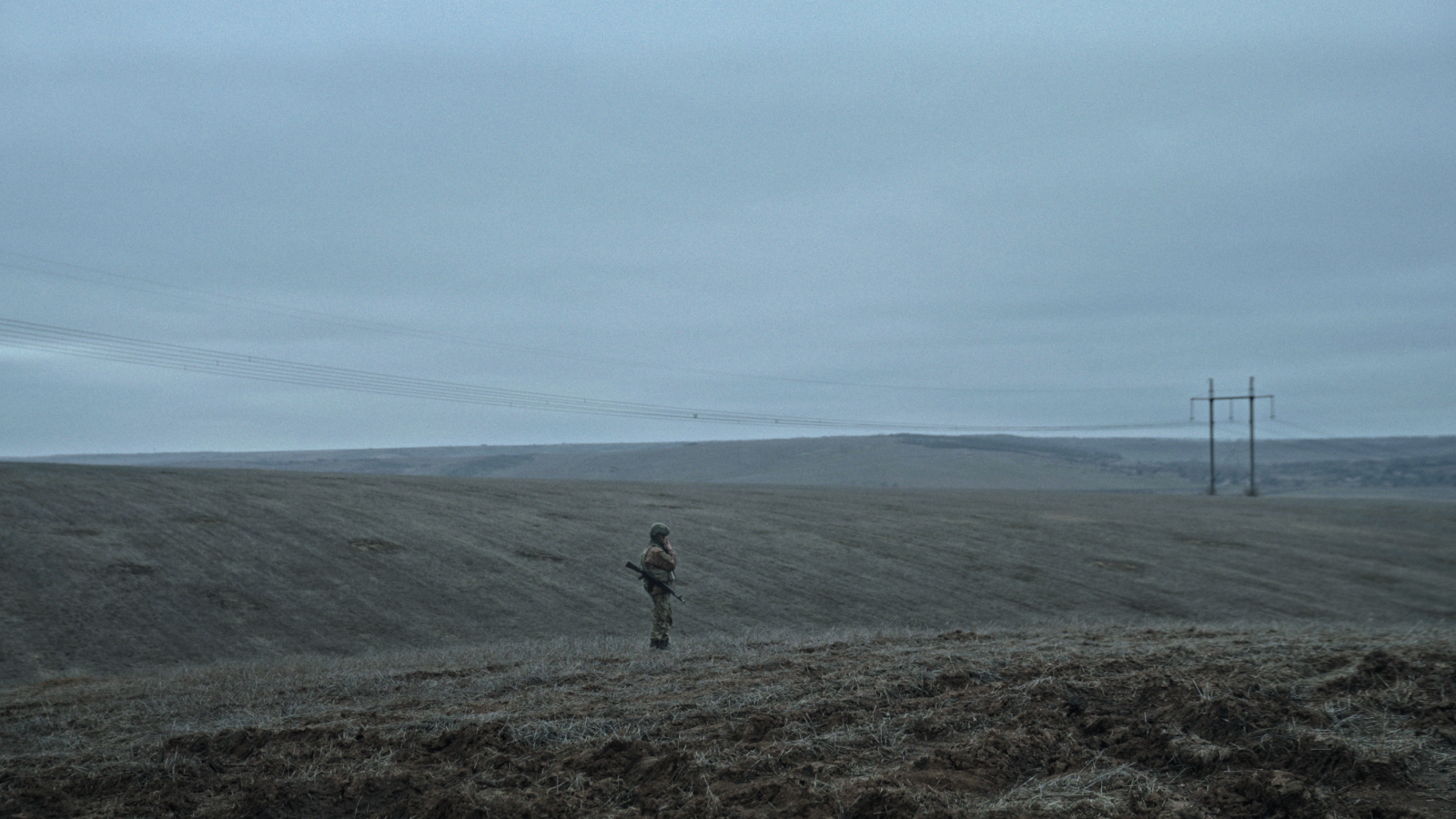 eng: A military man stands in a field.