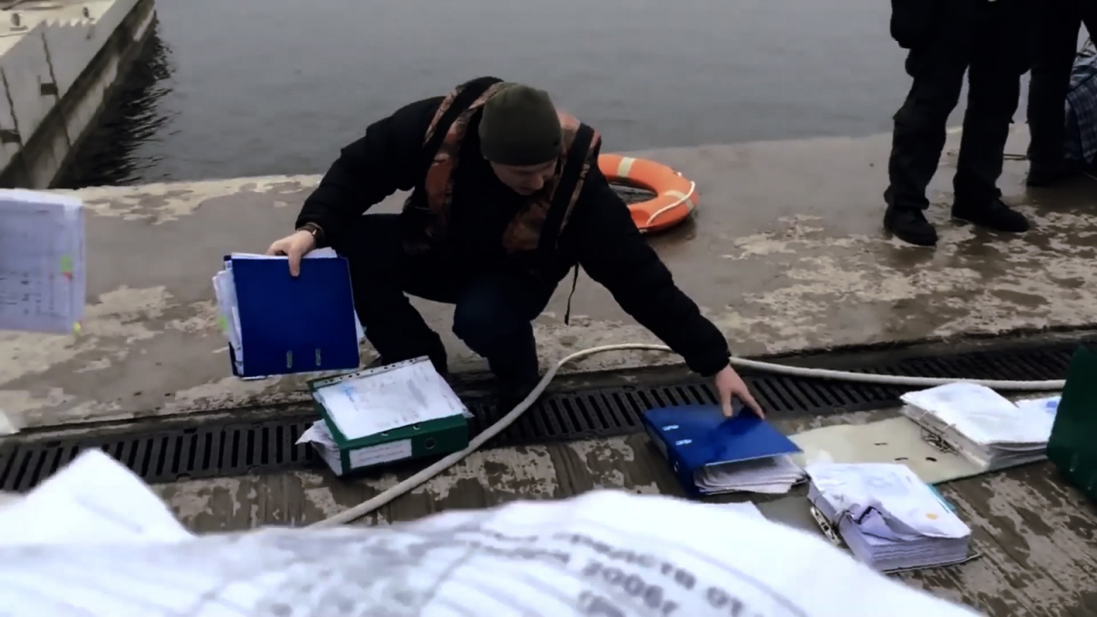 eng: A man is holding flooded folders with documents.