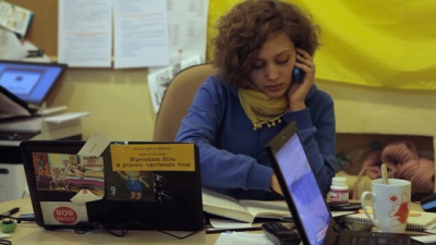 The young woman is calling on her mobile phone. Ukrainian flag on the background.